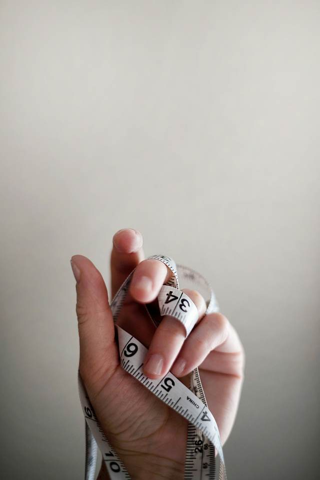 Een hand met een lintmeter